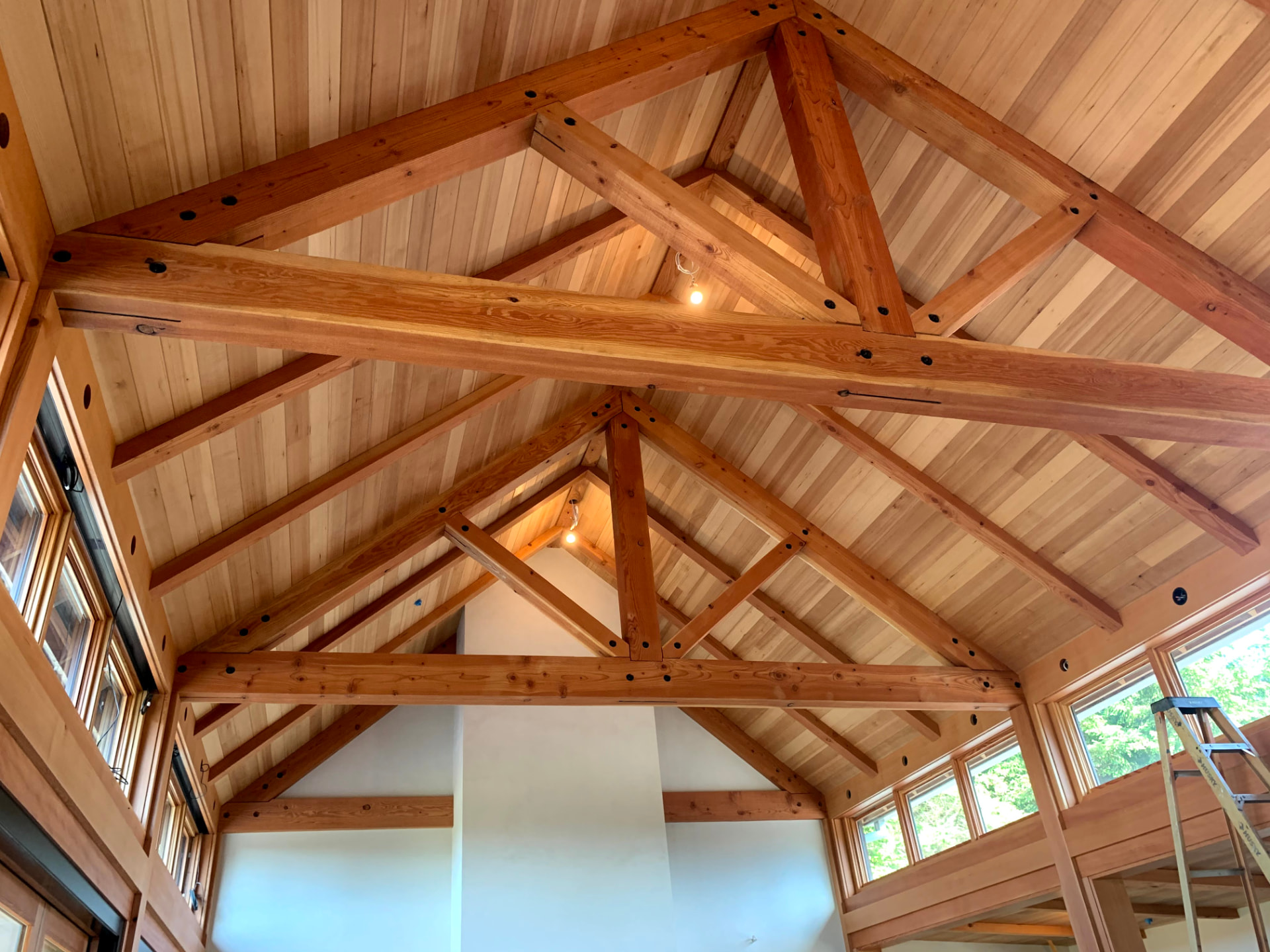 Vaulted wood ceiling with exposed beams and recessed lighting