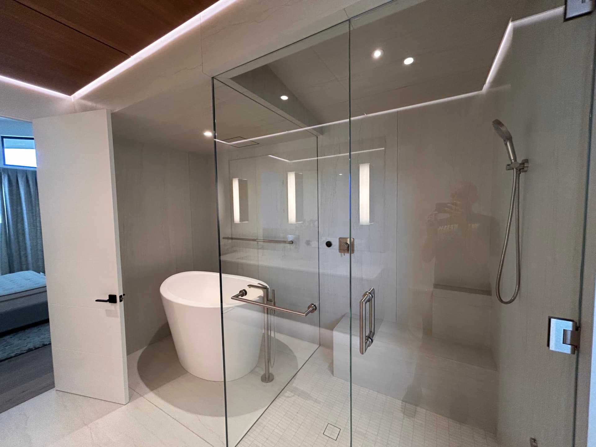 Glass shower and freestanding tub with recessed lighting